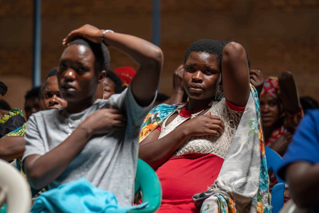 Des productrices de café apprennent l'auto-examen des seins dans une station de lavage au Rwanda.